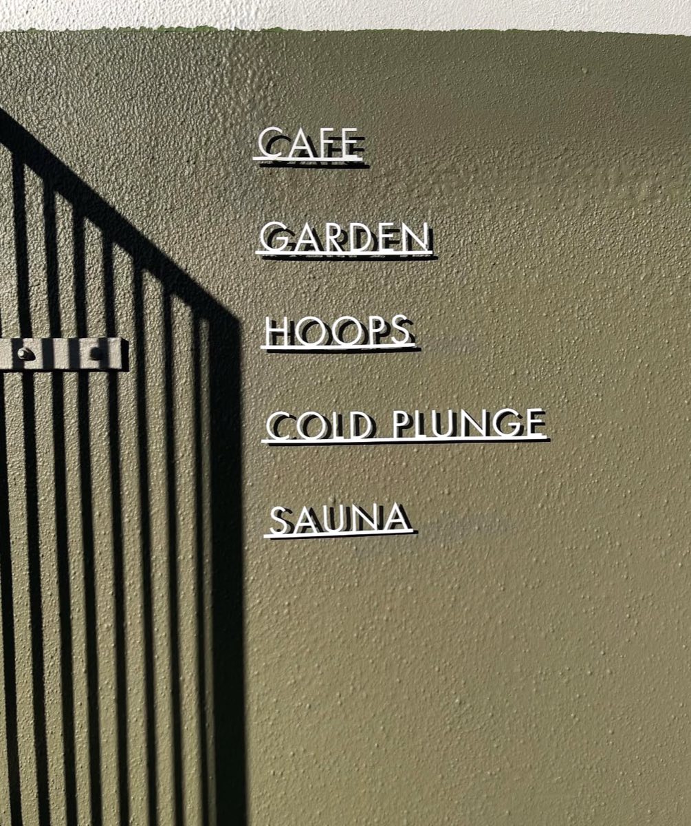 Signage at Ark listing cafe, garden, hoops, cold plunge and sauna